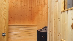 Una sala de sauna con paredes y bancos de madera.