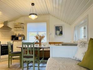 A cozy kitchen with a dining area, a bed, and a window with a view. - 4 Person Holiday Home in Kopmannebro-by Traum (Köpmannebro)