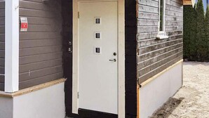 A small, single-story building with a white door and a small window. - 5 Person Holiday Home in Frederikstad (Fredrikstad)