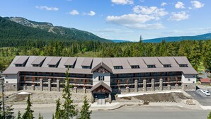 A lodge with multiple floors, a stone facade, and a central entrance with a porch. - Ask about summer discounts! Walk to Govy/Ski Bowl, Garage parking, Sleeps 8 (Government Camp)