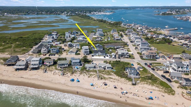Zona residencial costera con casas, una playa y un puerto deportivo.