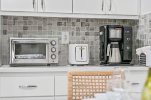A kitchen with a microwave, toaster, and coffee maker on the counter.