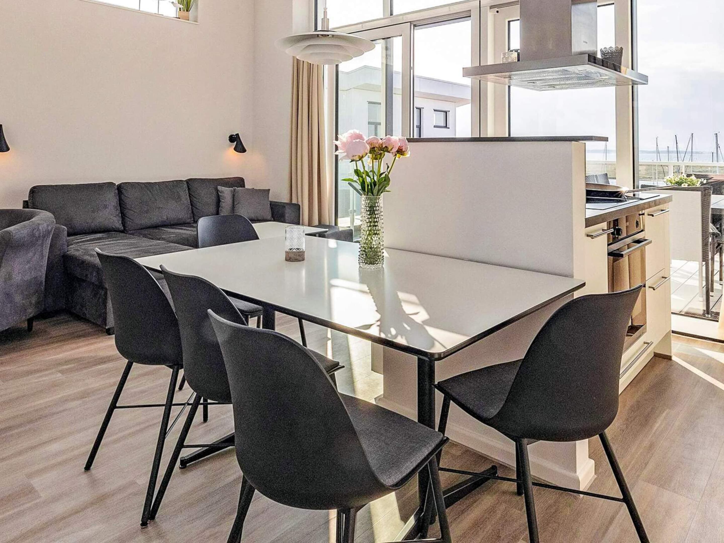 Ein zeitgemäßer Wohnraum mit Essbereich, einer Couch und einer Küche.