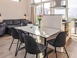 Un espacio habitable moderno con comedor, sofá y cocina.