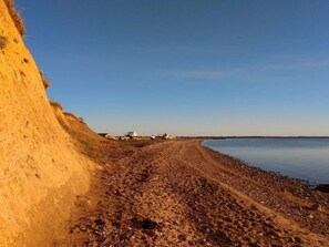 A beach with a dirt path leading to a building with a sign. - 6 Person Holiday Home in Oster Assels (Øster Assels)
