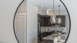 A modern kitchen with dark wooden cabinets, a granite countertop, and pendant lighting. - Modern Mountain 3BR Near Donner Lake & Trails (Truckee)