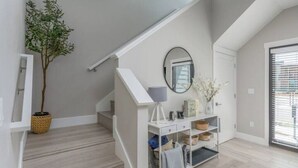A staircase with a white console table, a mirror, and a potted plant. - Modern Mountain 3BR Near Donner Lake & Trails (Truckee)