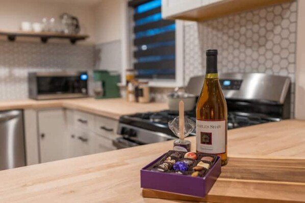 Een keuken met een fles wijn, een doos chocolade en een magnetron.