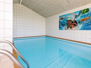 Piscina com um mural de personagens animados na parede.