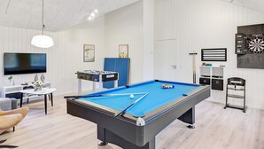 A modern living room with a pool table, a television, and a dartboard. - 5 Star Holiday Home in Vaeggerlose (Vaeggerlose)