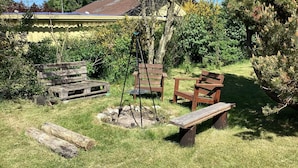 A rustic outdoor seating area with wooden benches and a swing set.