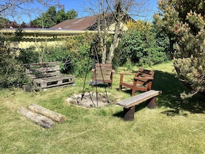 A rustic outdoor seating area with wooden benches and a swing set.