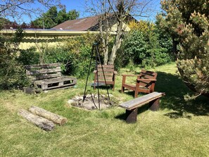 A backyard with a wooden bench, a swing set, and a fire pit. - 4 Star Holiday Home in Dannemare (Dannemare)