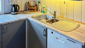 A modern kitchen with a double sink, a coffee maker, and a dish soap dispenser. - 4 Person Holiday Home in Skulestadmo (Voss)