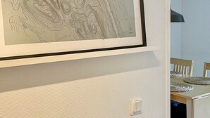 A framed topographic map on a wall, a switch, and a dining area with chairs and a table. - 5 Person Holiday Home in Salen (Salen)