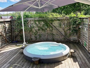 A hot tub on a wooden deck with a wooden fence and greenery in the background. - 4 Star Holiday Home in Paryd (Påryd)