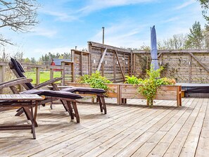 A wooden deck with lounge chairs and planters. - 4 Star Holiday Home in Paryd (Påryd)