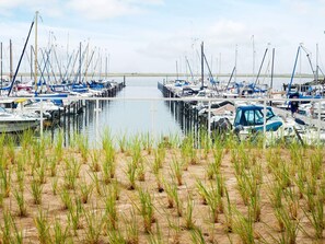 A marina with boats docked along the water's edge, surrounded by grassy areas. - 5 Star Holiday Home in Wendtorf (Wendtorf)