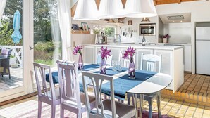 A modern kitchen with white cabinets, a central island, and pendant lighting. - 4 Star Holiday Home in Fjerritslev (Fjerritslev)