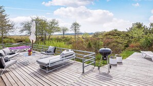A deck with outdoor furniture, a grill, and a view of the landscape. - 4 Star Holiday Home in Fjerritslev (Fjerritslev)