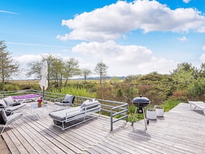 Une terrasse dotée de mobilier d’extérieur, d’un barbecue et offrant une vue sur le paysage.