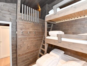 A bunk bed room with wooden walls and a ladder.