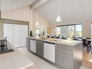 A modern kitchen with a central island, built-in appliances, and pendant lighting.