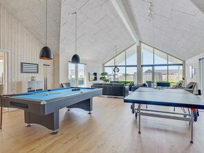 Un grand espace intérieur comprenant une table de billard, une table de snooker et une table de pool.