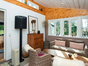 A cozy living room with a sofa, a coffee table, and a floor lamp. - 4 Star Holiday Home in Ebeltoft (Ebeltoft)
