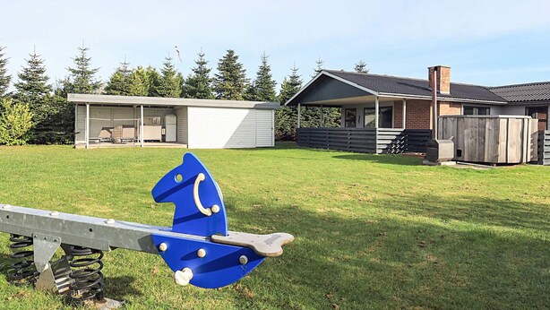 A playground with a blue horse-shaped swing set in a grassy yard. - 8 Person Holiday Home in Otterup (Otterup)