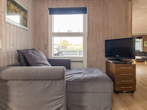 A modern living room with a sofa, a flat-screen TV, and a wooden cabinet. - 8 Person Holiday Home in Otterup (Otterup)