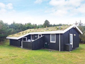 A black building with a sloped roof, a small porch, and a window. - 6 Person Holiday Home in Blokhus (Blokhus)