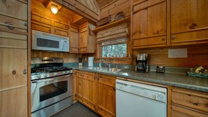 Kitchen features a stainless steel stove, microwave, sink, and dishwasher.