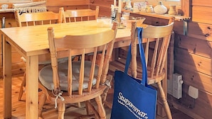 A wooden interior with a round wooden table and chairs, a lamp, and a blue tote bag with text. - 5 Person Holiday Home in Sexdrega-by Traum (Sexdrega)