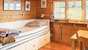A cozy cabin-style room with a built-in bed, wooden walls, a small kitchen area, and a window with a view of the outdoors. - 5 Person Holiday Home in Sexdrega-by Traum (Sexdrega)