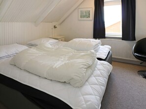 A single bed with a white duvet in a room with white walls and a sloped ceiling. - 10 Person Holiday Home in Hadsund (Hadsund)