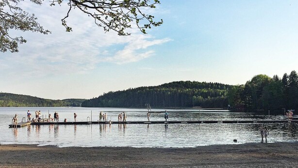 A beach with a dock and people swimming. - 5 Person Holiday Home in Lerum-by Traum (Lerum)