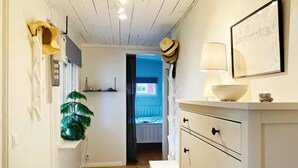 A narrow hallway with a white cabinet, a plant, and a bed visible in the background. - 4 Person Holiday Home in Bottnaryd-by Traum (Bottnaryd)