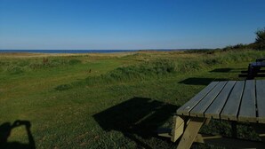 A picnic table in a grassy area with a view of the sea. - 6 Person Holiday Home in Orsted (Ørsted)