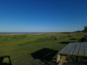 A picnic table in a grassy area with a view of the sea. - 6 Person Holiday Home in Orsted (Ørsted)
