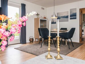 A dining area with a table, chairs, and a candle centerpiece. - 6 Person Holiday Home in Orsted (Ørsted)