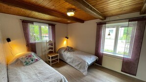 A room with two beds, a wooden ceiling, and windows with curtains. - 4 Person Holiday Home in Everod (Everöd)
