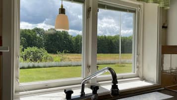 A kitchen with a window, a sink, and a hanging light fixture.