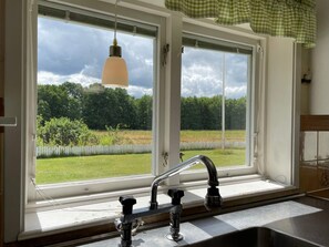A kitchen with a window, a sink, and a hanging light fixture. - 4 Person Holiday Home in Everod (Everöd)