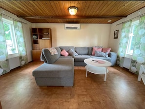 A living room with a grey sectional sofa, a white coffee table, and a wooden ceiling. - 4 Person Holiday Home in Everod (Everöd)