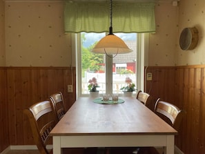 A dining area with a wooden table and chairs, a hanging lamp, and a window with a view of the outside. - 4 Person Holiday Home in Everod (Everöd)