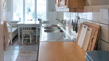 A kitchen with a wooden countertop, a sink, and a window.