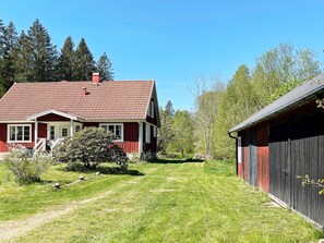A red house with a white porch and a black barn. - 4 Star Holiday Home in Hallabro (Hallaröd)