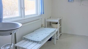 A small, bright room with a window, a radiator, a white table, and a shelf unit. - 4 Star Holiday Home in Hallabro (Hallaröd)