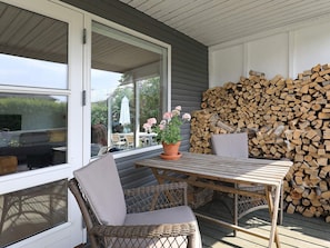 A covered patio with wicker chairs, a table, and a potted plant. - 3 Person Holiday Home in Kerteminde-by Traum (Kerteminde)